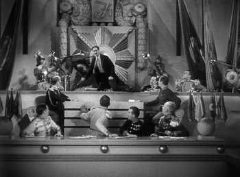 Movie still from “Duck Soup” (1933), directed by Leo McCarey – A black and white photo of a group of people sitting around; Extreme Wide shot, Low angle