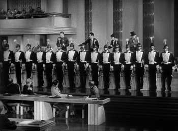 Movie still from “Duck Soup” (1933), directed by Leo McCarey – A black and white photo of men in tuxedos in a theater; Extreme Wide shot, High angle