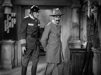 Movie still from “Duck Soup” (1933), directed by Leo McCarey – Two men in uniform standing next to each other in a room; Medium shot, Over the shoulder angle
