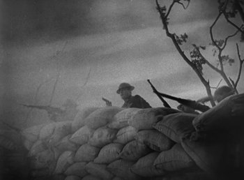 Movie still from “Duck Soup” (1933), directed by Leo McCarey – An old photo of a man sitting on a pile of sandbags; Extreme Close Up shot, Low angle