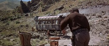Movie still from “Duck, You Sucker!” (1971), directed by Sergio Leone – An old fashioned wagon is being worked on by a man; Wide shot, Low angle