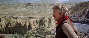 Movie still from “Duck, You Sucker!” (1971), directed by Sergio Leone – An older man with a red bandanna looking out over a mountain range; Medium shot, Low angle