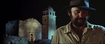 Movie still from “Duck, You Sucker!” (1971), directed by Sergio Leone – A man wearing a hat standing in front of a building; Close Up shot, Low angle