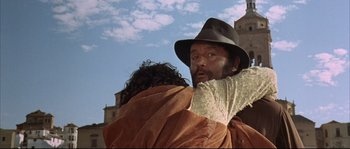 Movie still from “Duck, You Sucker!” (1971), directed by Sergio Leone – A man in a hat is holding a woman in a blanket; Medium shot, Low angle
