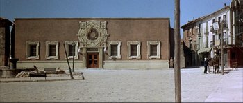 Movie still from “Duck, You Sucker!” (1971), directed by Sergio Leone – A building that has a clock on the side of the building; Extreme Wide shot, Low angle