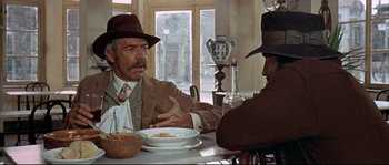 Movie still from “Duck, You Sucker!” (1971), directed by Sergio Leone – Two men sitting at a table with a bowl of pasta; Medium shot, Over the shoulder angle