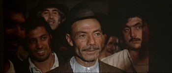 Movie still from “Duck, You Sucker!” (1971), directed by Sergio Leone – An older man wearing a hat in a crowd of people; Close Up shot, Low angle