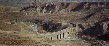 Movie still from “Duck, You Sucker!” (1971), directed by Sergio Leone – An old stone bridge in the middle of the desert; Extreme Wide shot, High angle