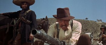 Movie still from “Duck, You Sucker!” (1971), directed by Sergio Leone – A man with a hat and a gun in his hand; Medium shot, Low angle