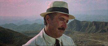 Movie still from “Duck, You Sucker!” (1971), directed by Sergio Leone – A person wearing a hat with mountains in the background; Close Up shot, Low angle