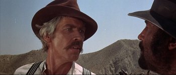 Movie still from “Duck, You Sucker!” (1971), directed by Sergio Leone – A person wearing a hat with mountains in the background; Close Up shot, Low angle