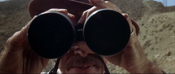 Movie still from “Duck, You Sucker!” (1971), directed by Sergio Leone – A person looking through binoculars; Extreme Close Up shot, Low angle