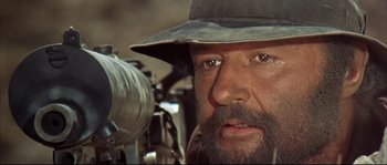 Movie still from “Duck, You Sucker!” (1971), directed by Sergio Leone – A man with a beard wearing a hat; Close Up shot, Over the shoulder angle