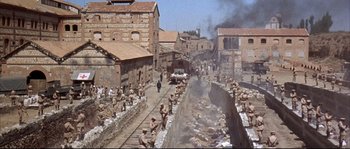 Movie still from “Duck, You Sucker!” (1971), directed by Sergio Leone – An image of an industrial area in the middle of a city; Extreme Wide shot, High angle