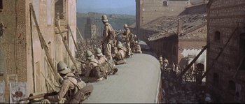 Movie still from “Duck, You Sucker!” (1971), directed by Sergio Leone – A group of soldiers sitting on top of a building; Wide shot, High angle