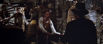 Movie still from “Duck, You Sucker!” (1971), directed by Sergio Leone – A man standing in front of a wooden barrel; Medium shot, Over the shoulder angle