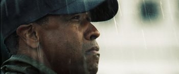 Movie still from “Deja Vu” (2006), directed by Tony Scott – A person wearing a hat looking out a window; Close Up shot, Low angle