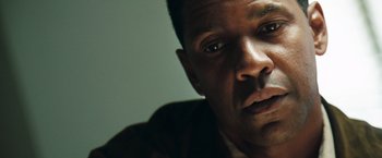 Movie still from “Deja Vu” (2006), directed by Tony Scott – A man's face in a dark room; Close Up shot, Low angle
