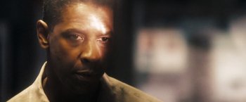 Movie still from “Deja Vu” (2006), directed by Tony Scott – A man's face in a dark room; Close Up shot, Over the shoulder angle