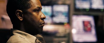 Movie still from “Deja Vu” (2006), directed by Tony Scott – A man's face in front of monitors; Close Up shot, Low angle
