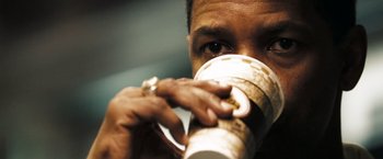 Movie still from “Deja Vu” (2006), directed by Tony Scott – A person drinking a cup of coffee; Extreme Close Up shot, Low angle