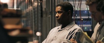 Movie still from “Deja Vu” (2006), directed by Tony Scott – A man standing in front of a wall with his hand on his shoulder; Close Up shot, Over the shoulder angle