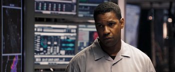 Movie still from “Deja Vu” (2006), directed by Tony Scott – A man standing in front of a wall with multiple monitors; Close Up shot, Over the shoulder angle