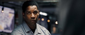 Movie still from “Deja Vu” (2006), directed by Tony Scott – A man in a gray shirt is looking at the camera; Close Up shot, Over the shoulder angle