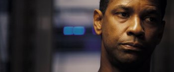 Movie still from “Deja Vu” (2006), directed by Tony Scott – A man's face with blue lights in the background; Close Up shot, Low angle
