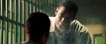 Movie still from “Deja Vu” (2006), directed by Tony Scott – A man standing next to another man in front of a window; Close Up shot, Over the shoulder angle
