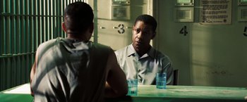 Movie still from “Deja Vu” (2006), directed by Tony Scott – A man sitting at a table in front of another man; Medium shot, Over the shoulder angle