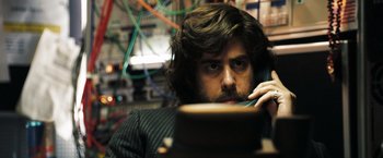 Movie still from “Deja Vu” (2006), directed by Tony Scott – A man with long hair and a beard talking on a phone; Close Up shot, Low angle