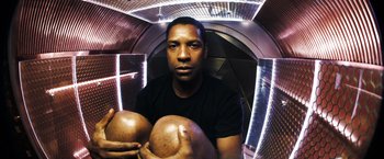 Movie still from “Deja Vu” (2006), directed by Tony Scott – A man holding two large balls in his hands; Close Up shot, Overhead angle