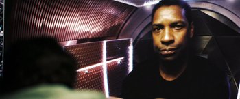 Movie still from “Deja Vu” (2006), directed by Tony Scott – A man sitting on a train looking into the camera; Close Up shot, Low angle