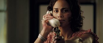 Movie still from “Deja Vu” (2006), directed by Tony Scott – A woman holding a gun while talking on the phone; Close Up shot, Low angle