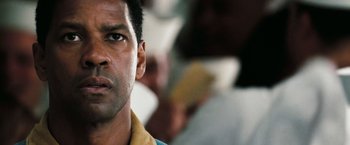 Movie still from “Deja Vu” (2006), directed by Tony Scott – A man's face in front of a group of people; Close Up shot, Low angle