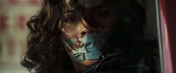 Movie still from “Deja Vu” (2006), directed by Tony Scott – A woman with a mouth taped shut with blood on her mouth; Close Up shot, Low angle