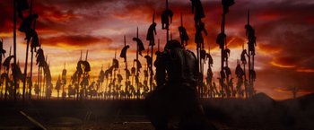 Movie still from “Dracula Untold” (2014), directed by Gary Shore – A man kneeling in front of a bunch of statues; Extreme Wide shot, Low angle