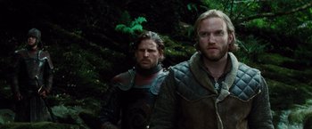 Movie still from “Dracula Untold” (2014), directed by Gary Shore – Two men standing next to each other near some trees; Medium shot, Low angle