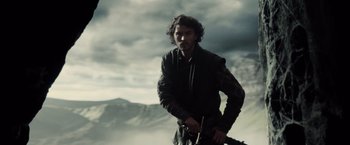 Movie still from “Dracula Untold” (2014), directed by Gary Shore – A man holding a sword while standing on top of a hill; Medium shot, Low angle