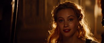Movie still from “Dracula Untold” (2014), directed by Gary Shore – A beautiful woman with long blonde hair and blue eyes looking at the camera; Close Up shot, Over the shoulder angle