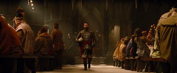 Movie still from “Dracula Untold” (2014), directed by Gary Shore – A man dressed as a medieval knight walking through a crowd; Wide shot, Over the shoulder angle