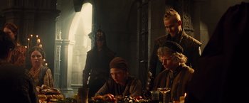Movie still from “Dracula Untold” (2014), directed by Gary Shore – A group of people sitting around a table; Medium shot, Over the shoulder angle