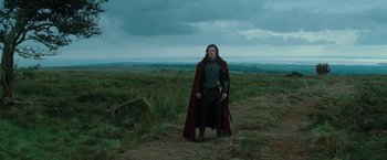 Movie still from “Dracula Untold” (2014), directed by Gary Shore – A man standing in the middle of a grassy field; Wide shot, Low angle