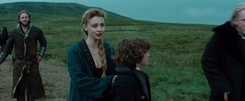 Movie still from “Dracula Untold” (2014), directed by Gary Shore – A woman standing next to a young boy in a field; Medium shot, Over the shoulder angle