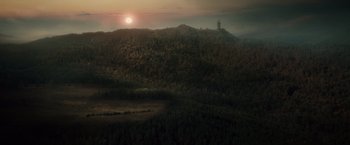 Movie still from “Dracula Untold” (2014), directed by Gary Shore – The sun is setting over a hill with a tower in the distance; Extreme Wide shot, High angle