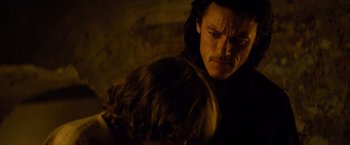 Movie still from “Dracula Untold” (2014), directed by Gary Shore – A person holding a child in a dark room; Close Up shot, Over the shoulder angle