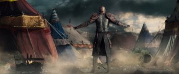 Movie still from “Dracula Untold” (2014), directed by Gary Shore – A man standing in front of a tent in the middle of a field; Wide shot, Low angle