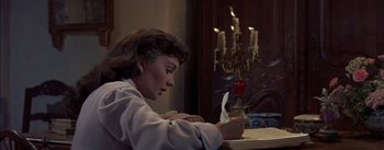 Movie still from “Désirée” (1954), directed by Henry Koster – A woman sitting at a table writing on a piece of paper; Medium shot, High angle