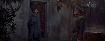 Movie still from “Désirée” (1954), directed by Henry Koster – A man in a robe and a woman in a black dress; Wide shot, High angle